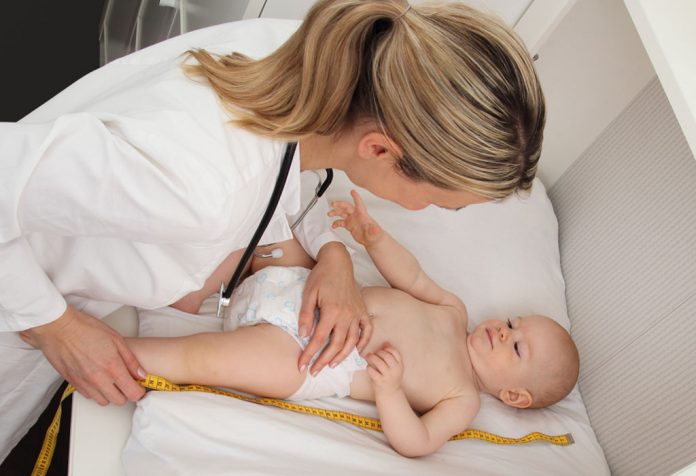 A doctor measuring an infant's size