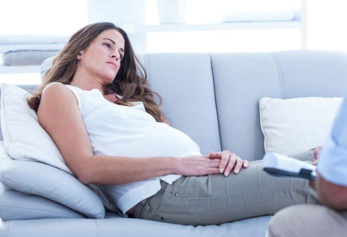 Pregnant woman resting on the couch in a daze