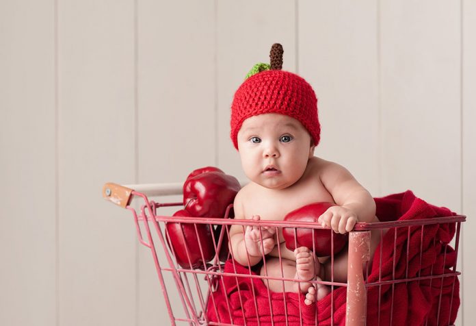 A baby wearing an apple hat