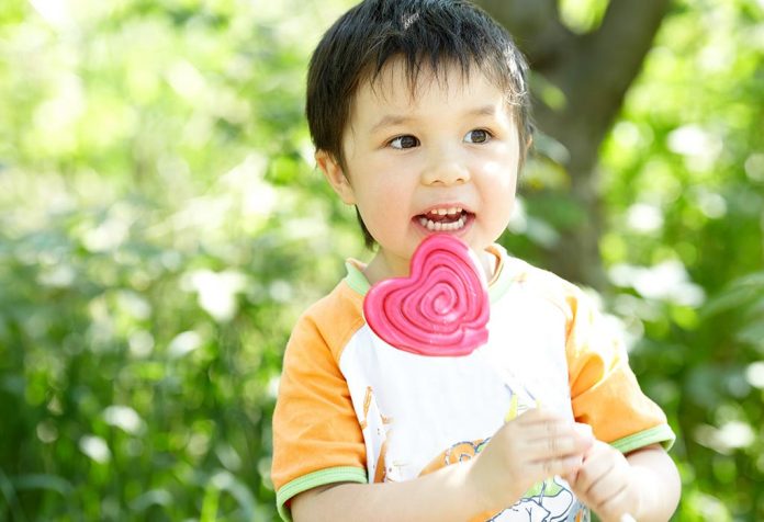 A kid eating lollipop