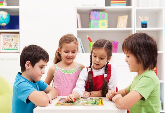 Four kids playing a board game